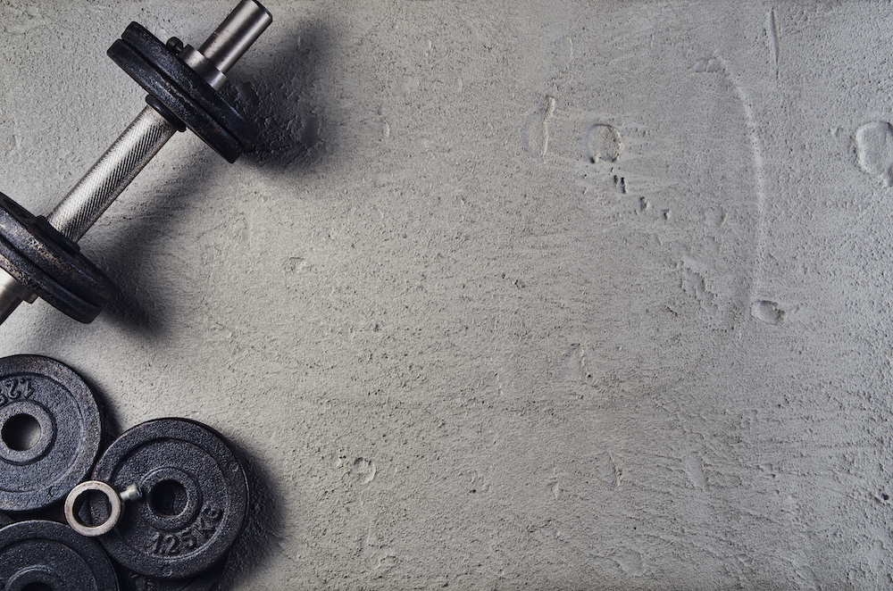 Fitness or bodybuilding background. Dumbbells on gym floor, top view