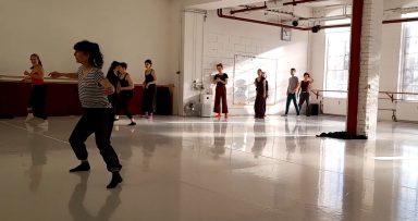 Tanzgruppe in einem hellen Studio, verschiedene Tänzer in Bewegung.